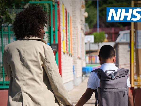 Mum and school-aged son walking holding hands